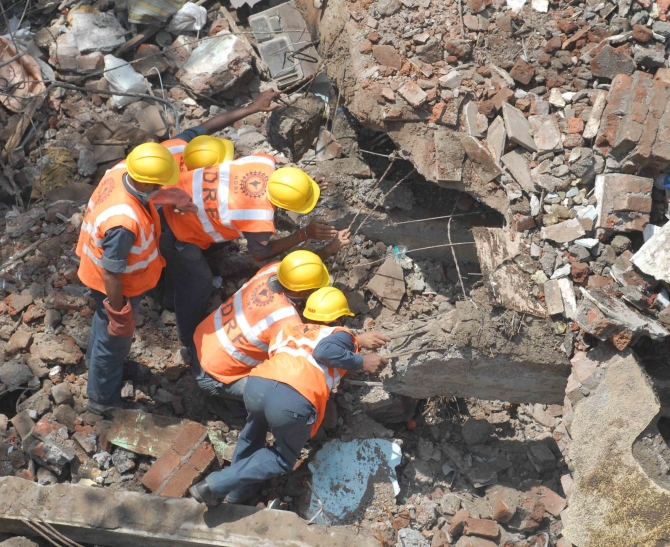 Firemen look for survivors in the debris at the site of the crash in Mazgaon, Mumbai 