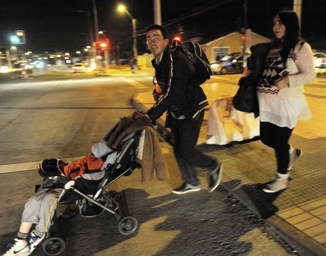 Residents walk to higher ground after a Tsunami alarm at Talcahuano city, south of Santiago on the southern Pacific coast