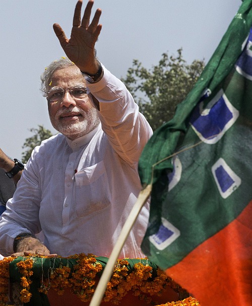 BJP leader Narendra Modi waves on his way to filing his nomination papers on April 24, 2014 in Varanasi