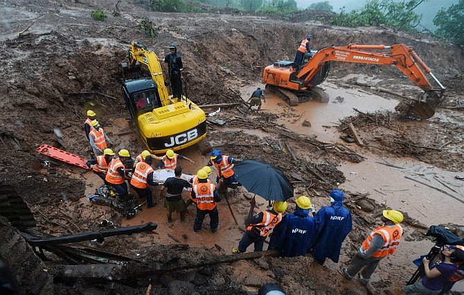 Rescue workers clear the debris at the site of a landslide in Malin village in Pune, Maharashtra