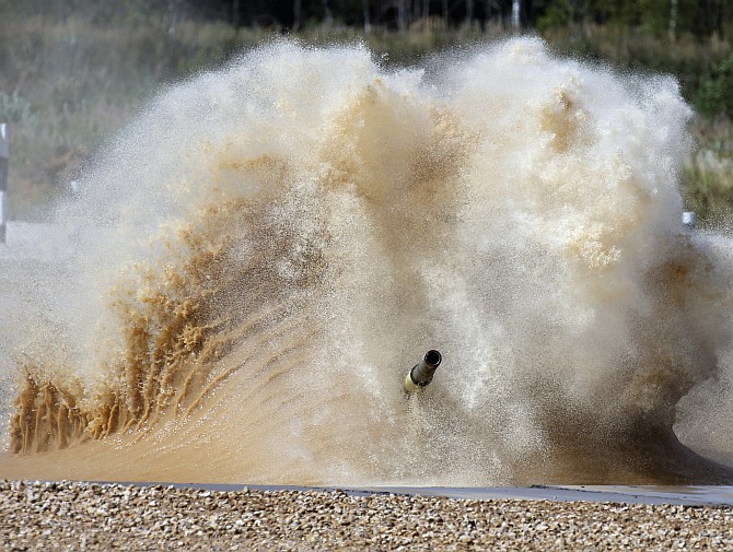 A tank drives through a water obstacle on the course of the Tank Biathlon world championship in Alabino outside Moscow