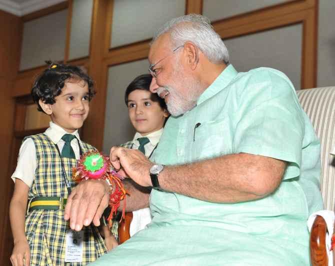 Children tying Rakhi onto the wrist of Prime Minister Narendra Modi in New Delhi on Sunday