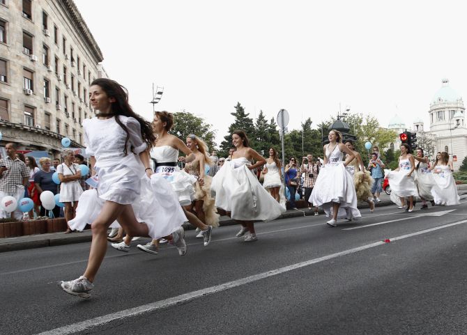 Women dressed in bridal gowns spring during the annual Bridal race in central Belgrade. 
