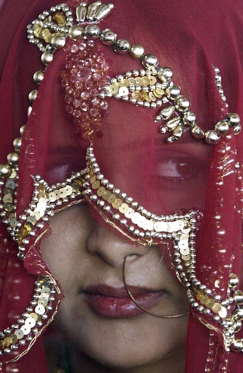 A Muslim bride sits during a mass wedding ceremony
