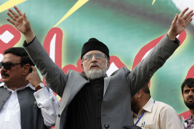 Muhammad Tahirul Qadri, Sufi cleric and leader of political party Pakistan Awami Tehreek gestures to supporters.