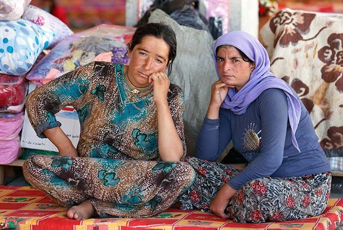 Women rest in an abandoned building being used with other displaced people as their main residence outside the city of Dohuk.