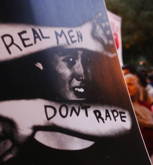 Demonstrators hold placards during a candlelight vigil to mark the first death anniversary of the Delhi gang rape victim in New Delhi.