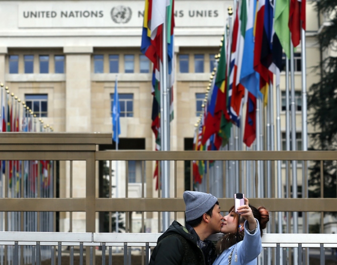 A couple takes a selfie in front of the United Nations European headquarters in Geneva.