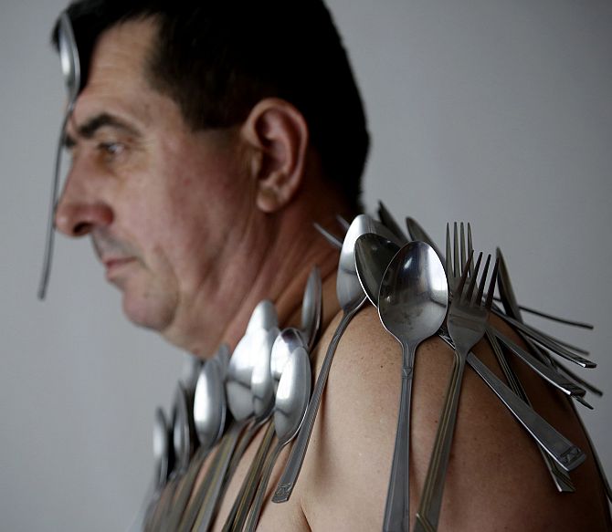 Muhibija Buljubasic, 56, poses for photo with cutlery on his body and head in Srebrenik