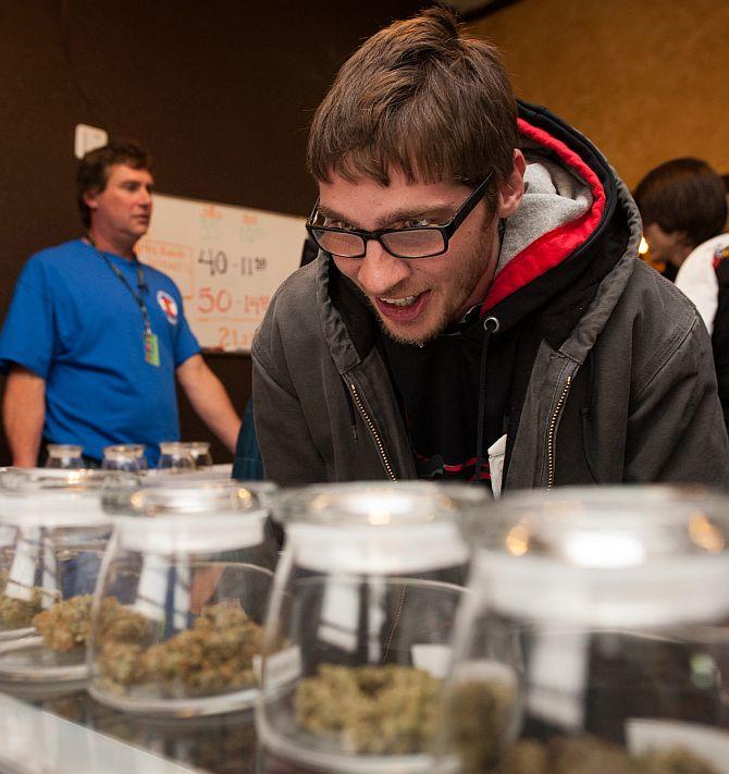 Tyler Williams of Blanchester, Ohio selects marijuana strains to purchase at the 3-D Denver Discrete Dispensary on January 1, 2014 in Denver, Colorado