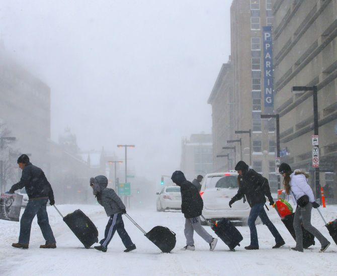 Travelers leave the Back Bay subway station during a winter nor'easter snow storm in Boston, Massachusetts on Friday