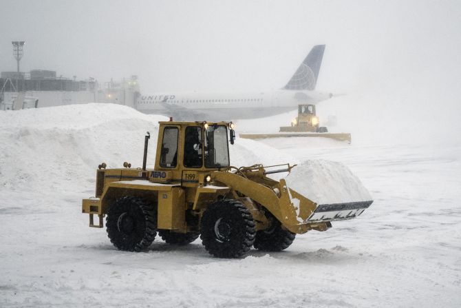 Heavy machinery clears the snow at LaGuardia Airport during a winter storm in New York, on Friday