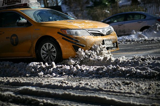 A taxi cab drives into a pile of snow on East End Ave. near E. 86th St. after an overnight storm dropped up to 7 inches of snow