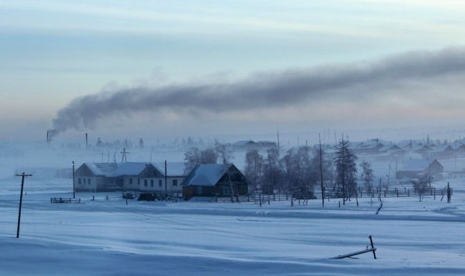 Smoke rises above houses in the village of Maralayi, in the Republic of Sakha, northeast Russia. The coldest temperatures in the northern hemisphere have been recorded in Sakha, the location of the Oymyakon valley,