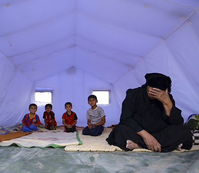  A family, who fled from the violence in Mosul, sits inside a tent at a camp on the outskirts of Arbil in Iraq's Kurdistan region