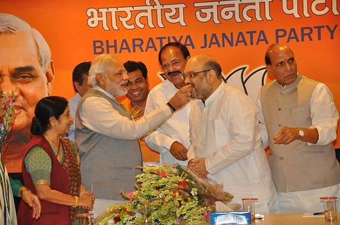 Prime Minister Narendra Modi offers sweets to new BJP president Amit Shah. Also seen are Sushma Swaraj, Venkaiah Naidu and Rajnath Singh