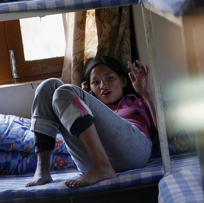 A girl speaks on a mobile phone at a hostel