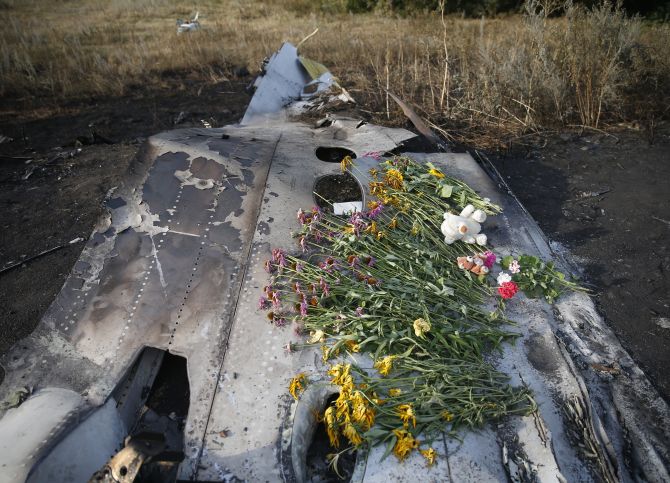 Flowers and mementos lie on wreckage at the crash site of Malaysia Airlines Flight MH17, near the settlement of Grabovo in the Donetsk.