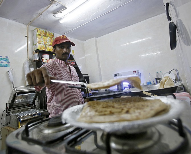 An inmate prepares food inside the kitchen of a restaurant run by the Tihar Jail authorities