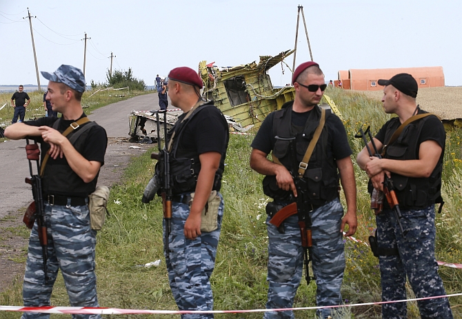  Armed pro-Russian separatists stand guard at a crash site of Malaysia Airlines Flight MH17