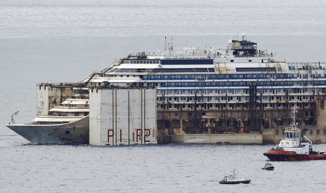 Tug boats tow the Costa Concordia ship as they arrive outside Genoa's port, in northern Italy, where the ship will be broken up for scrap.