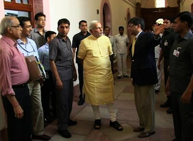 Prime Minister Narendra Modi makes a round of the PMO soon after assuming office. On extreme left, in the pink shirt, is Nripendra Misra, principal secretary to the prime minister.