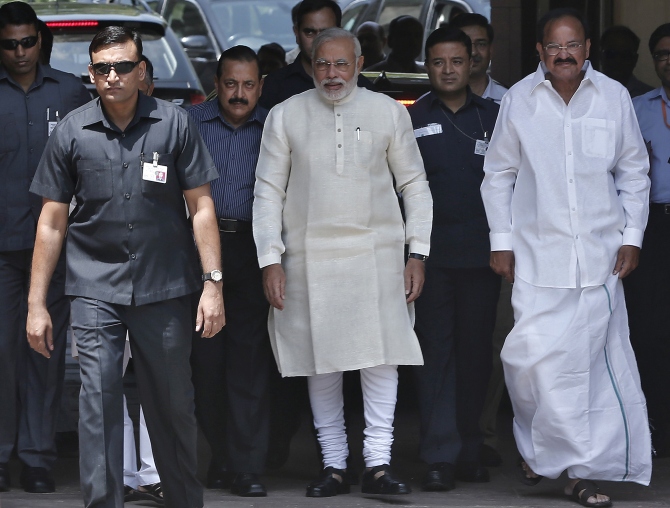 Prime Minister Narendra Modi walks with Parliamentary Affairs Minister Venkaiah Naidu to speak with the media in New Delhi. 