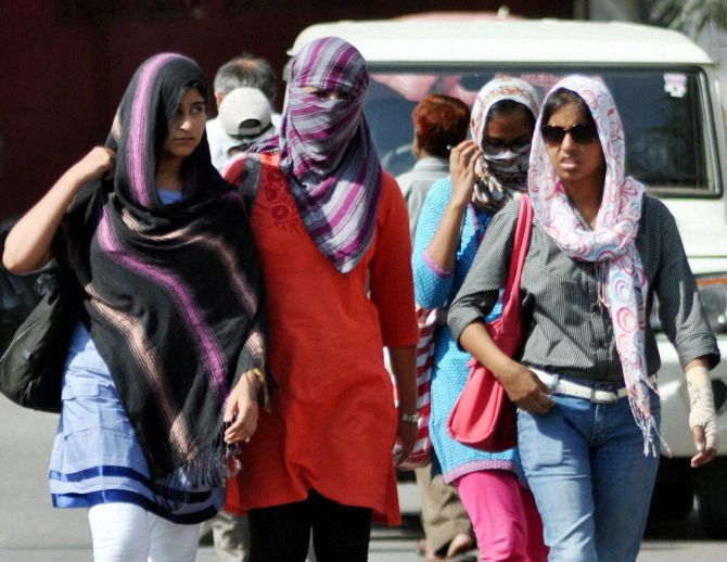  Women cover their heads with scarves as they try to protect themselves from the heat in Lucknow
