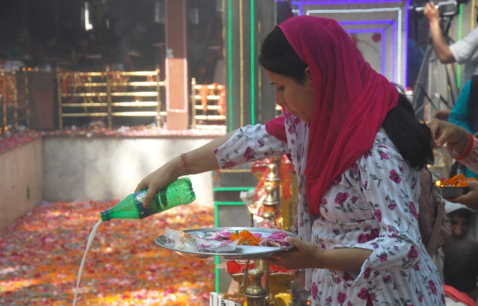 A devotee offers milk to the deity during the mela