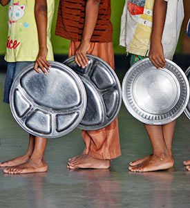 Children holding plates wait in a queue to receive food at a Chennai-based orphanage run by a non-governmental organisation.