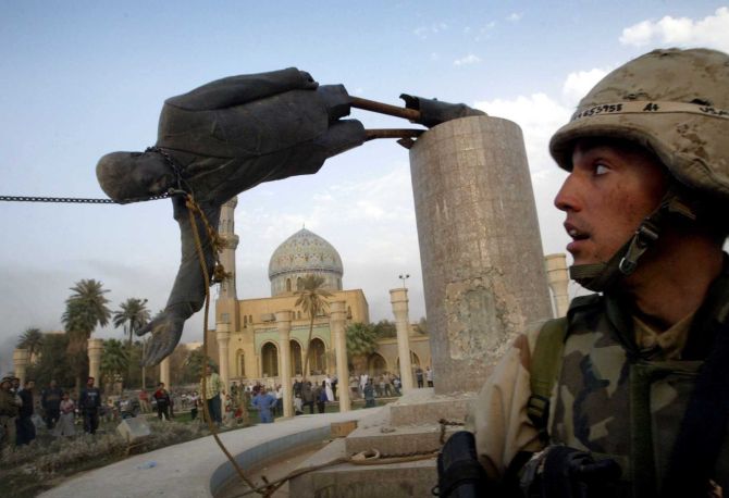 US Marine Corp watches as a statue of then Iraq's President Saddam Hussein falls in central Baghdad's Firdaus Square.