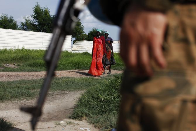 Women walk towards a U.N. peacekeeper patrolling in Bentiu, Unity State