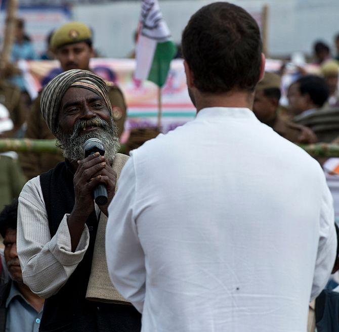 A rickshaw-puller interacts with Rahul Gandhi outside the Cantonment Railway Station in Varanasi