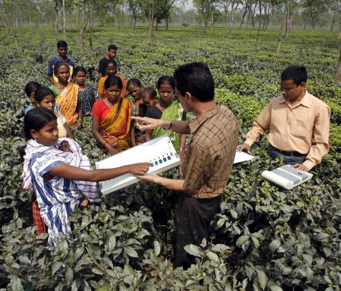 An election officer demonstrates how to use an Electronic Voting Machine  during an awareness programme in Siliguri