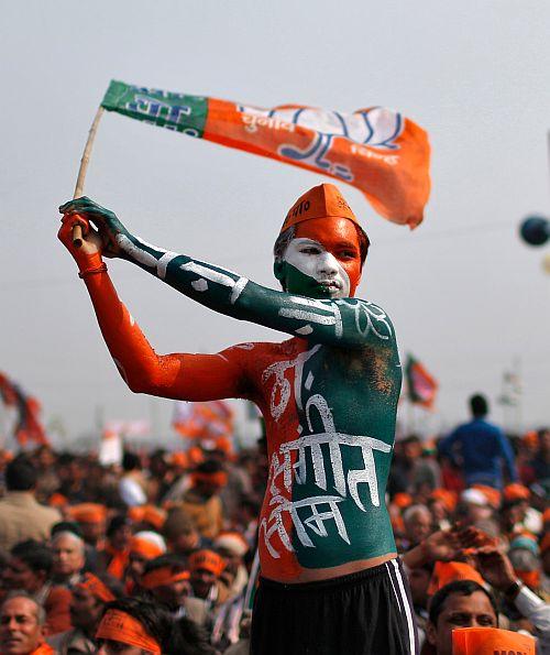 A BJP supporter waves the party's flag during Narendra Modi's rally in Uttar Pradesh