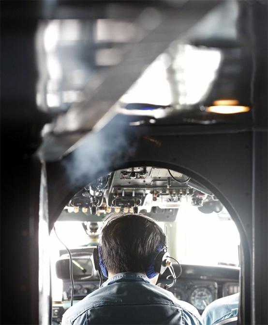 A military personnel works on board a Vietnamese airforce AN-26 during a mission to find missing Malaysia Airlines flight