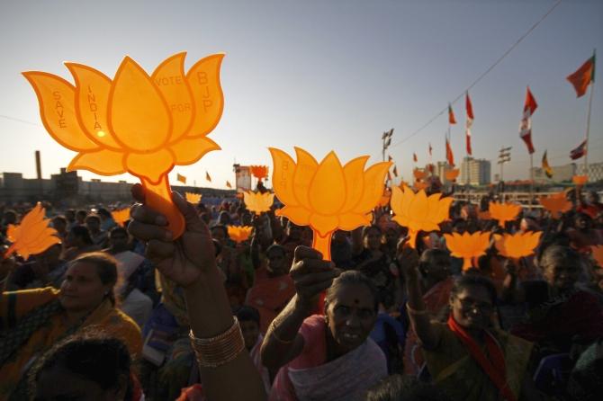 Modi supporters hold BJP symbols during a rally being addressed by Modi in Chennai.