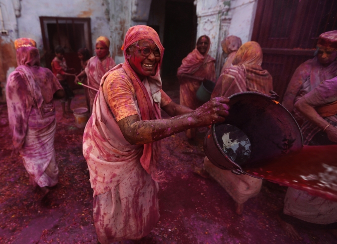 A widow throws coloured water during Holi celebrations at the ashram