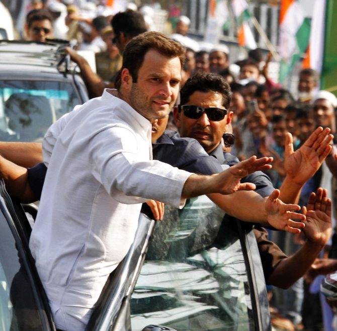 Rahul Gandhi waves to supporters during a campaign road show in Assam 