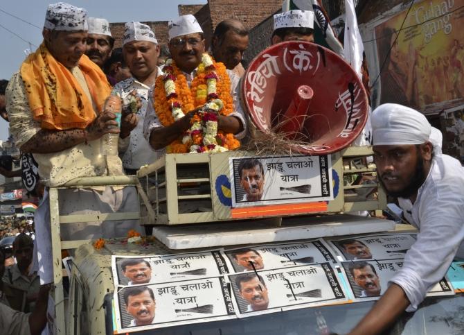 AAP leader Arvind Kejriwal stands atop a vehicle after ink was hurled at him and other party workers during a public rally in Varanasi 