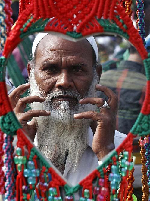 A Muslim man is reflected in a mirror