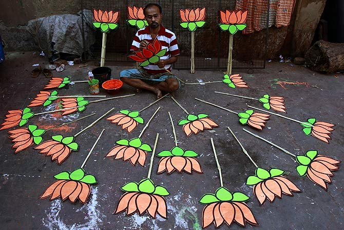 Kashinath Bagh paints cut-outs of lotuses, the BJP's party sumbol, at a workshop in Kolkata.