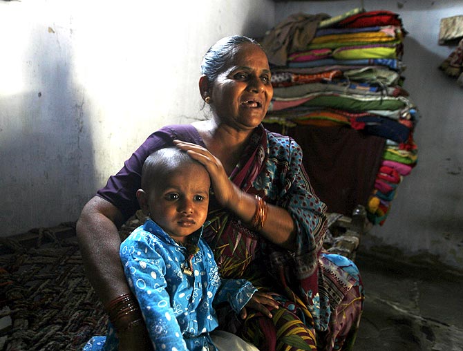 Hajira Sheikh, a riot survivor, with her grandson at her home in the rebuilt Naroda Patiya. Sheikh's invalid mother was burnt alive by a mob in the 2002 riots.