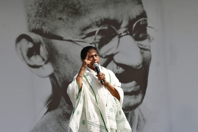 Mamata Banerjee, chief minister of West Bengal and Trinamool Congress chief, addresses her supporters in front of a portrait of Mahatma Gandhi during a rally ahead of the 2014 general elections, in New Delhi.