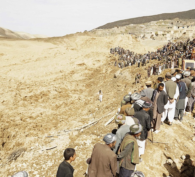 Afghan villagers gather at the site of the landslide at the Argo district in Badakhshan province