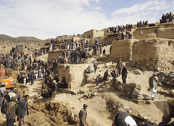 Afghan villagers gather at the site of the landslide at the Argo district in Badakhshan province