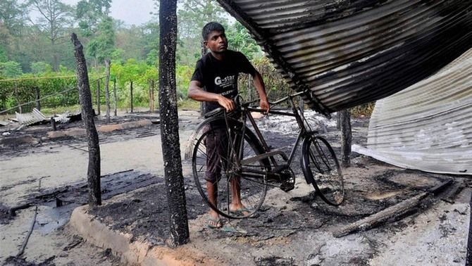 A survivor of Khagrabari village after his home was burnt down during violence. Photograph: PTI Photo.
