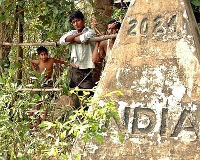 Bangladeshi residents watch as Indian officials prepare to build a fence on the border in Tripura in 2006