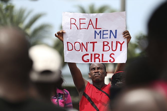 A man holds a placard as youths protest the release of abducted school girls in the remote village of Chibok, in Lagos