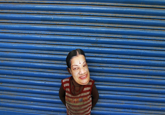 A boy wears a mask of Tamil Nadu CM J Jayalalithaa during a campaign in Chennai